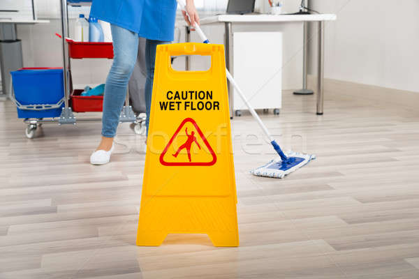 Janitor Mopping Floor By Wet Caution Sign In Office Stock photo © AndreyPopov