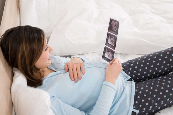 Kobieta w ciąży patrząc dźwięku obraz baby młodych Zdjęcia stock © AndreyPopov