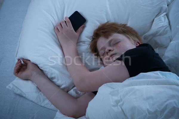 Boy Sleeping On Bed Stock photo © AndreyPopov
