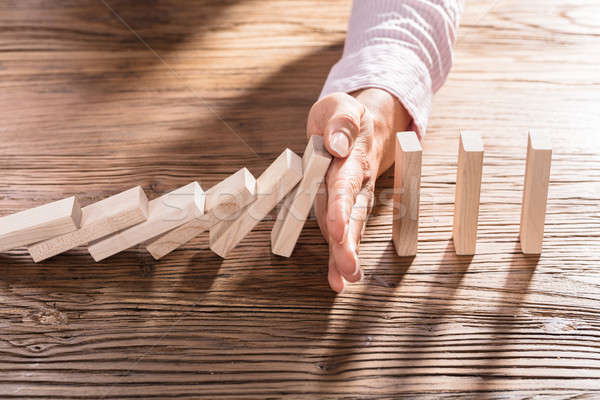 Female Hand Stopping The Domino From Falling Stock photo © AndreyPopov
