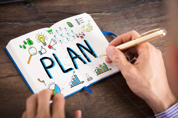 Businessperson Drawing The Plan Chart On Notebook Stock photo © AndreyPopov