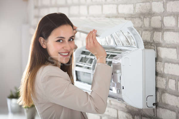 Woman Opening Air Conditioner Stock photo © AndreyPopov