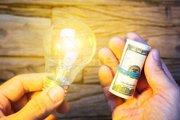 Hands Holding Dollar Notes And Lit Lightbulb Stock photo © AndreyPopov