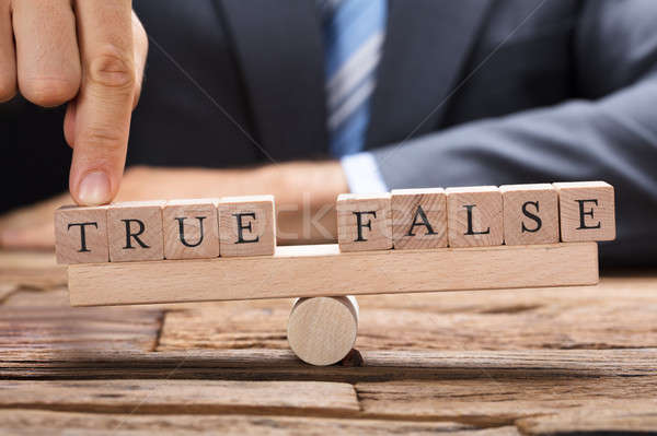 Stock photo: Businessman With True And False Blocks On Seesaw