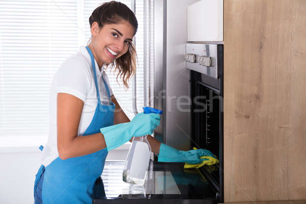 Woman In Protective Gloves Cleaning Oven Stock photo © AndreyPopov