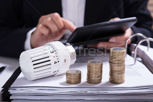 Mujer de negocios factura termostato monedas mesa oficina Foto stock © AndreyPopov