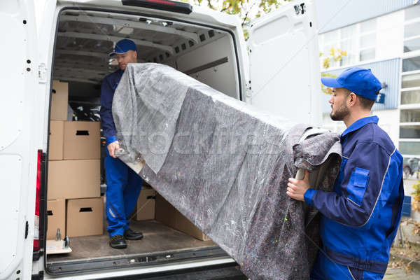 Two Delivery Men Unloading Furniture From Vehicle Stock photo © AndreyPopov