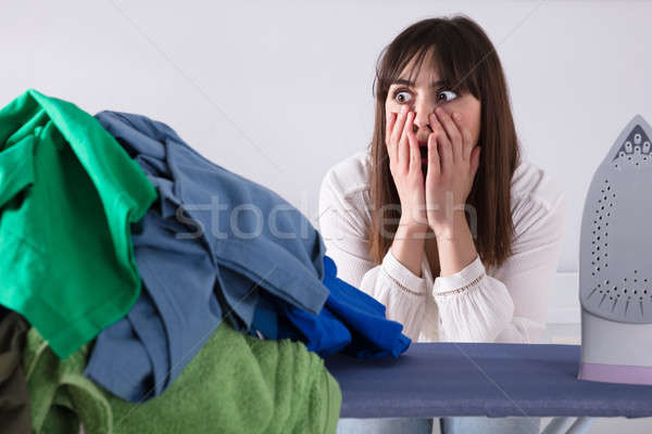 Shocked Woman Looking At Pile Of Clothes Stock photo © AndreyPopov