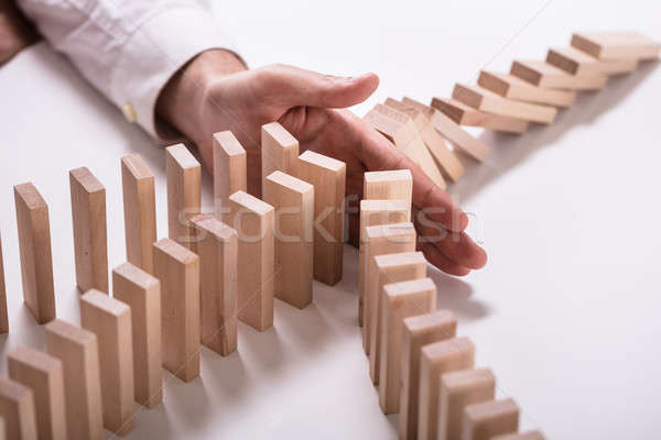Businessperson Stopping Wooden Blocks From Falling Stock photo © AndreyPopov