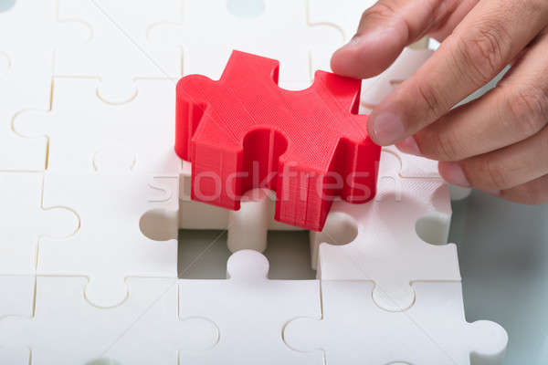 Businessman connecting red piece into white jigsaw puzzles Stock photo © AndreyPopov