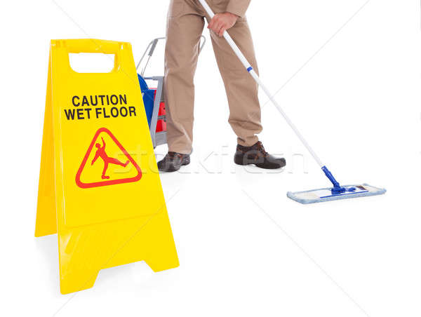 Stock photo: Sweeper Cleaning Floor With Warning Sign