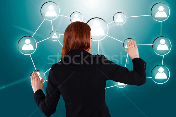 Businesswoman Touching Connected Human Icons Stock photo © AndreyPopov