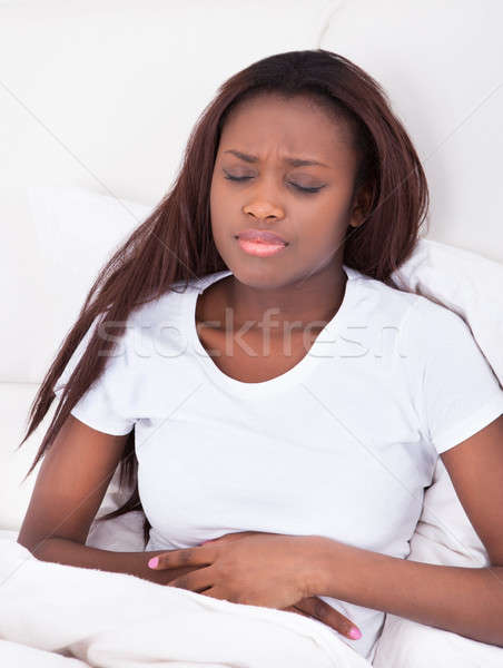 Woman Suffering From Stomachache In Bed Stock photo © AndreyPopov