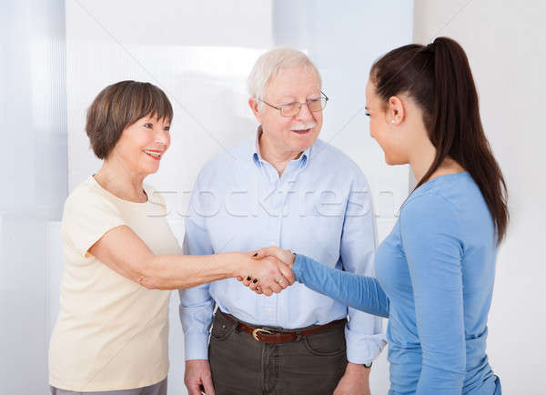 Stock photo: Caregiver Shaking Hands With Senior Couple