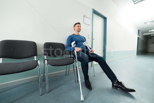 Człowiek kule kalekiego posiedzenia krzesło szpitala medycznych Zdjęcia stock © AndreyPopov