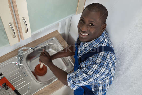 Plumber Using Plunger In Kitchen Sink Stock photo © AndreyPopov