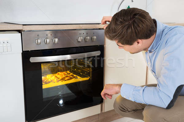 Man Baking Bread In Oven Stock photo © AndreyPopov