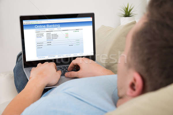 Man Using Online Banking On Laptop At Home Stock photo © AndreyPopov