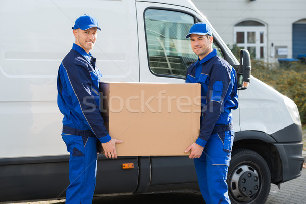 Delivery Men Carrying Cardboard Box Against Truck Stock photo © AndreyPopov