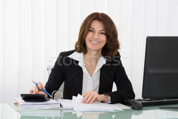 Happy Businesswoman Calculating Tax Stock photo © AndreyPopov