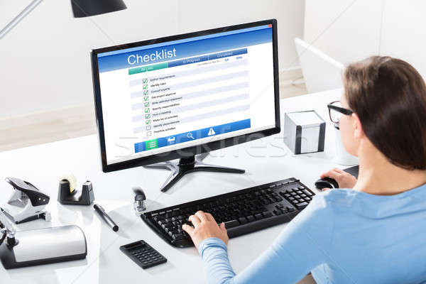 Stock photo: Businesswoman Filling Checklist Form On Computer