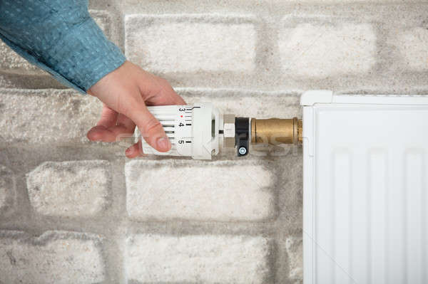 Person Adjusting Temperature Of Radiator Stock photo © AndreyPopov