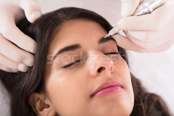 Cosmetologist Applying Permanent Make Up On Eyebrows Stock photo © AndreyPopov