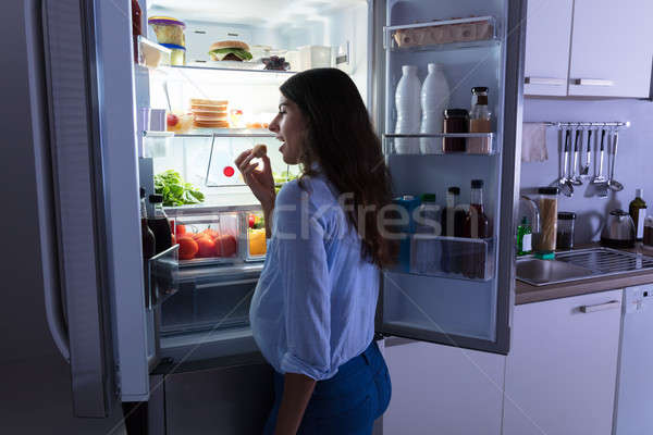ストックフォト: 女性 · 食べ · クッキー · キッチン · 若い女性 · 冷蔵庫