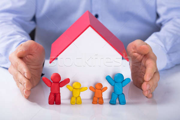 Hand Protecting The House Model With Colorful Family Stock photo © AndreyPopov