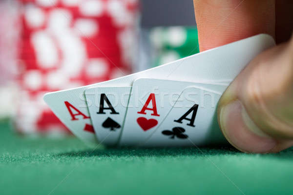 Stock photo: Poker player holding playing cards