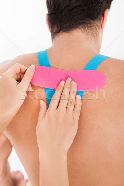 Woman Applying Physio Tape To Man Stock photo © AndreyPopov