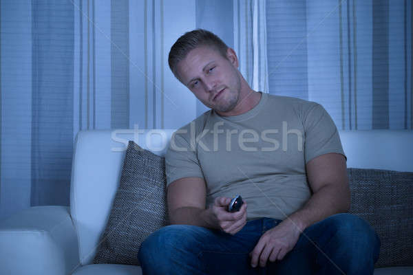 Man Watching Television On Sofa Stock photo © AndreyPopov