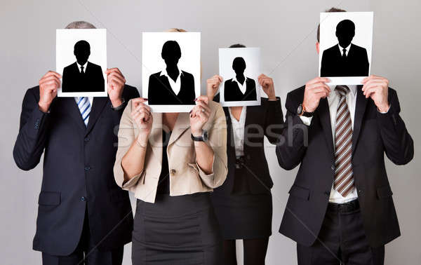 Businesspeople Holding Photographs In Front Of Faces Stock photo © AndreyPopov
