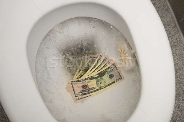 Stock photo: Flushing money down the toilet