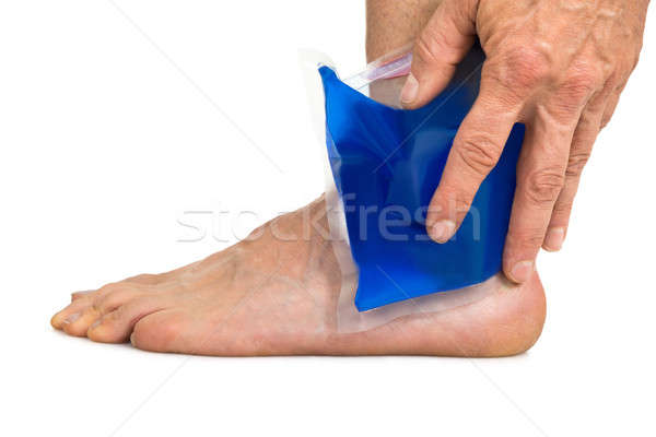 Hand Holding Cool Gel Pack On Ankle Stock photo © AndreyPopov