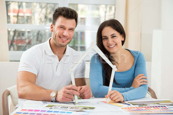 Young Couple With Model House Made Up Of Measurement Tape Stock photo © AndreyPopov