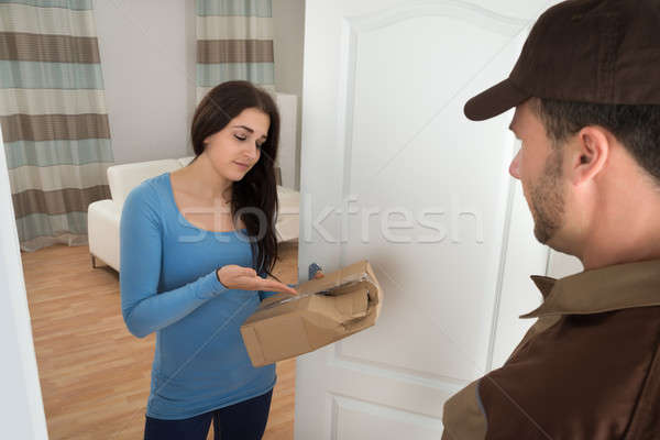 Woman Holding Damaged Package From Delivery Man Stock photo © AndreyPopov