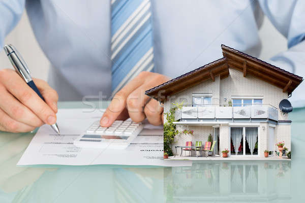 Businessman Calculating Expanses With House Model Stock photo © AndreyPopov