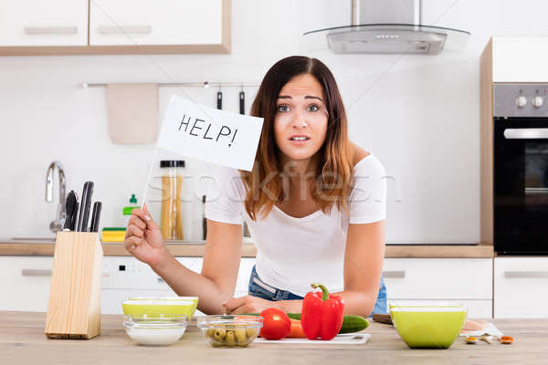 Woman Holding Help Flag In Kitchen Stock photo © AndreyPopov