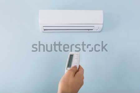 Woman Operating Air Conditioner With Remote Control Stock photo © AndreyPopov