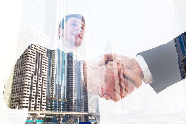 Businessman Shaking Hand With Coworker Over City Background Stock photo © AndreyPopov