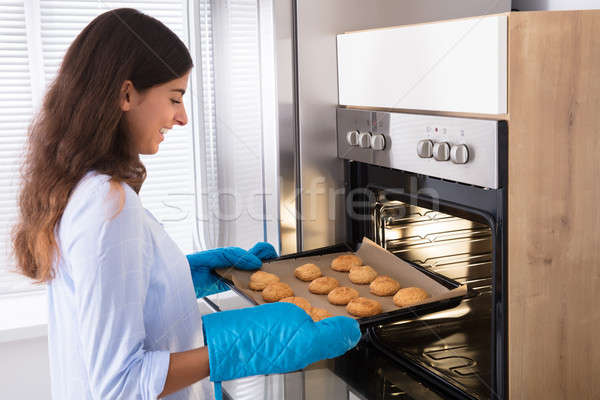 Femeie afara tava cookie-uri Imagine de stoc © AndreyPopov
