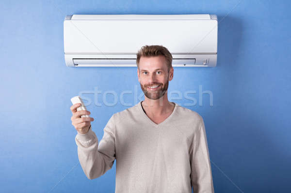 Young Man Standing In Front Of Air Condition Stock photo © AndreyPopov