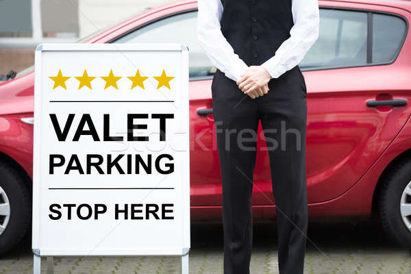 Young Male Valet Standing Near Valet Parking Sign Stock photo © AndreyPopov