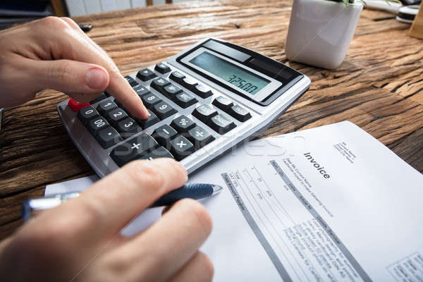 Person's Hand Calculating Invoice Stock photo © AndreyPopov