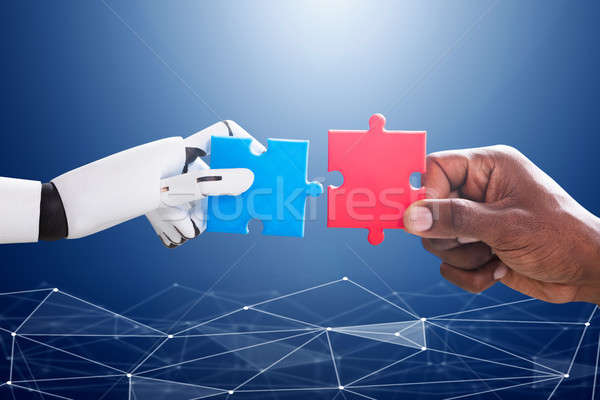 Robot And Human Hand Joining Jigsaw Stock photo © AndreyPopov