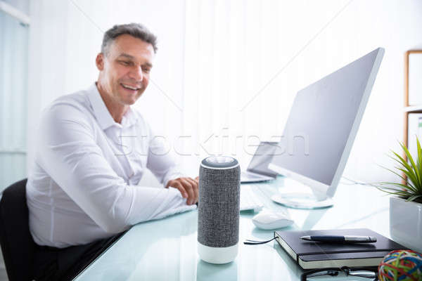 Man Listening To Wireless Speaker In Office Stock photo © AndreyPopov