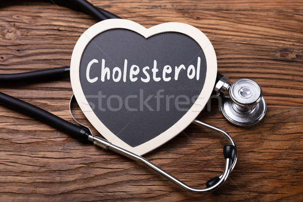 Stéthoscope coeur mot cholestérol bois surface Photo stock © AndreyPopov