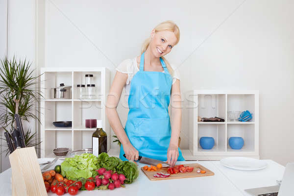 Cheerful young woman cooking Stock photo © AndreyPopov