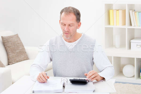 Dojrzały mężczyzna Kalkulator posiedzenia kanapie Zdjęcia stock © AndreyPopov